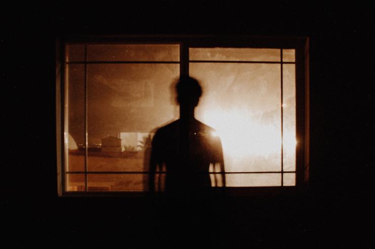 silhouette of a man looking out a window